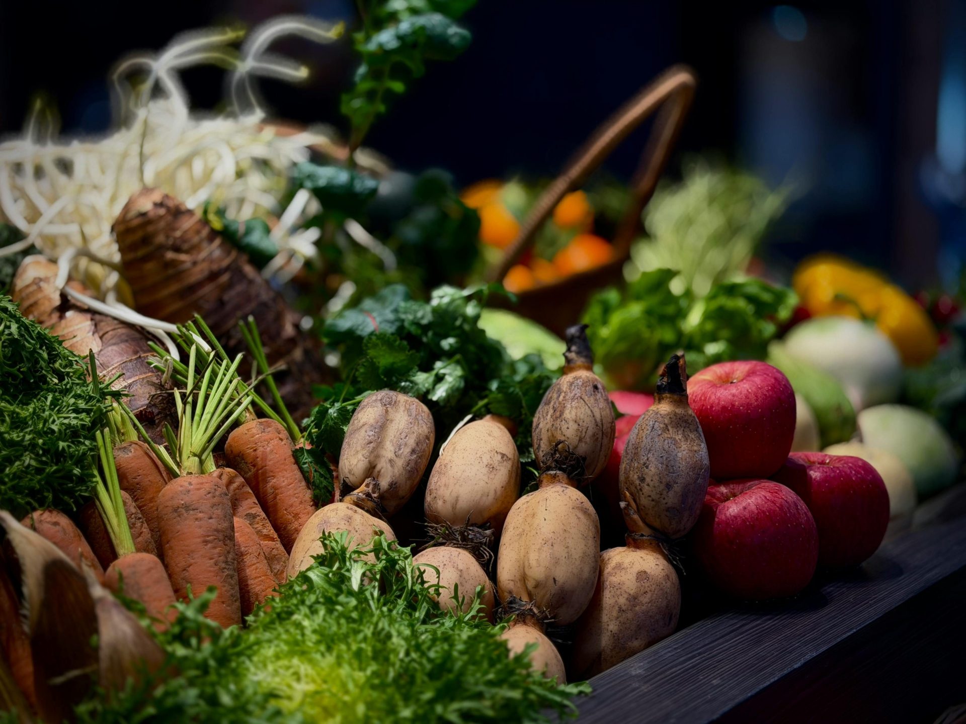 Una vibrante exhibición de frutas y verduras frescas, que incluye zanahorias, manzanas y hortalizas de hoja verde.